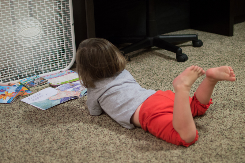 Reading books while the fan blows on her