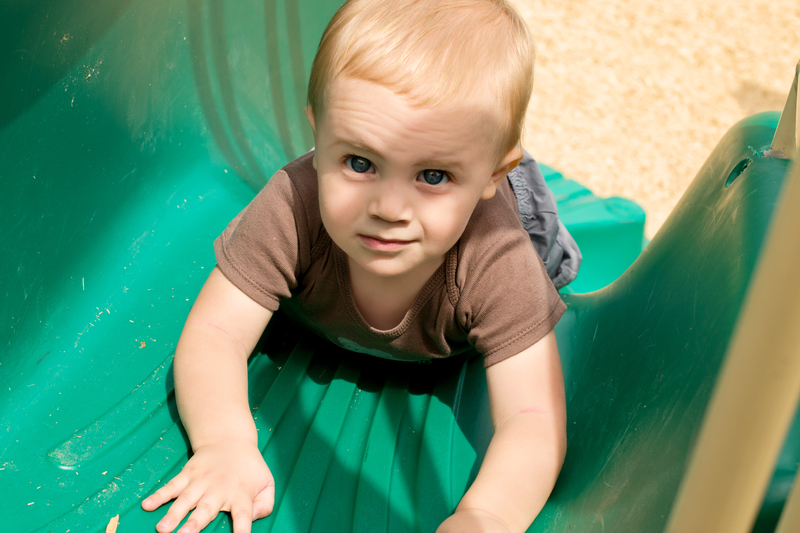 Sliding down the slide on his tummy