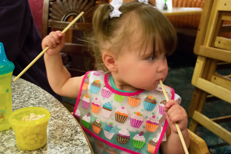 Using her chopsticks...