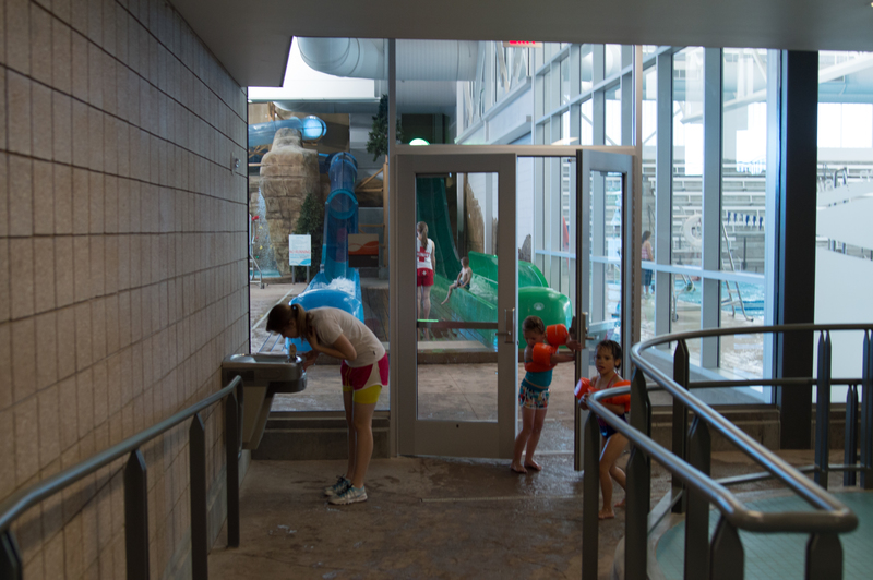 Door to the splash pad area, lazy river, kid lap pool, waterslides, and diving pool.