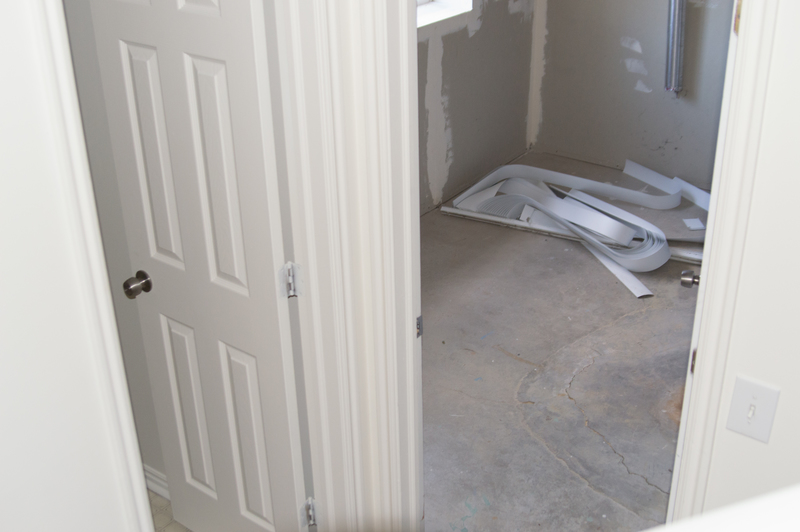 Bathroom at base of stairs with laundry room on right